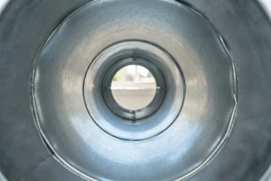Inside view of a clean, shiny metal dryer duct free of any lint or obstructions after professional maintenance.
